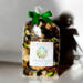 A bag of Irish Twins 'Cotton Fields' potpourri tied at the top with a green bow, casting a dark shadow on a clean, white background.